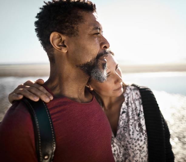 Woman leaning on man at beach