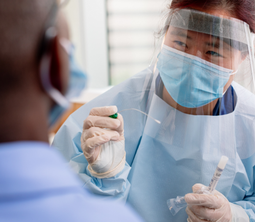 Nurse with face shield and mask collecting sample