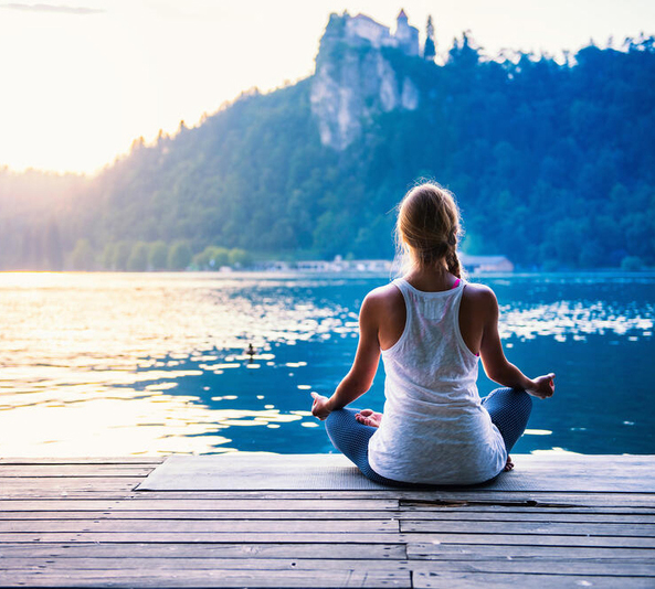 Woman meditating by the water