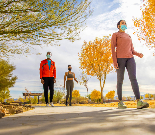 Masked people walking in a park