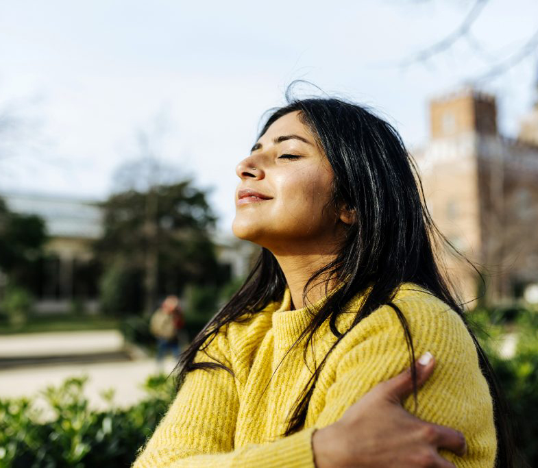 Woman closing eyes and smiling outside