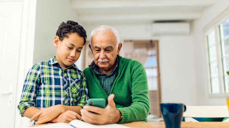 Grandfather and grandson looking at cellphone