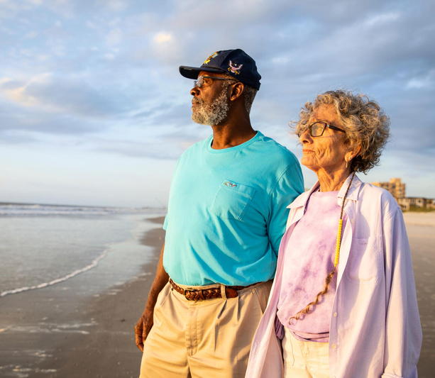 Older couple standing on beach