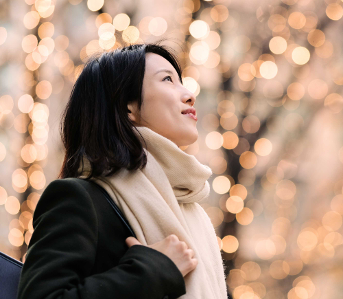 Young woman looking up at lights