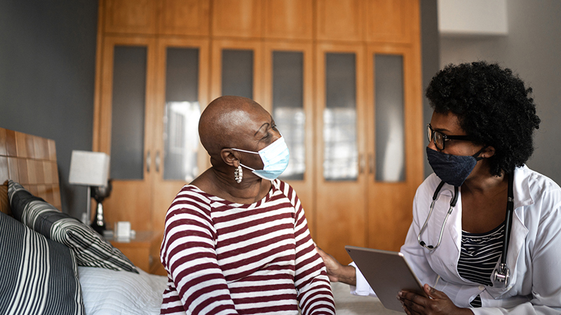 Masked doctor and patient talking