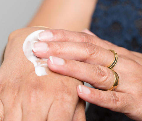 Woman putting lotion on hands