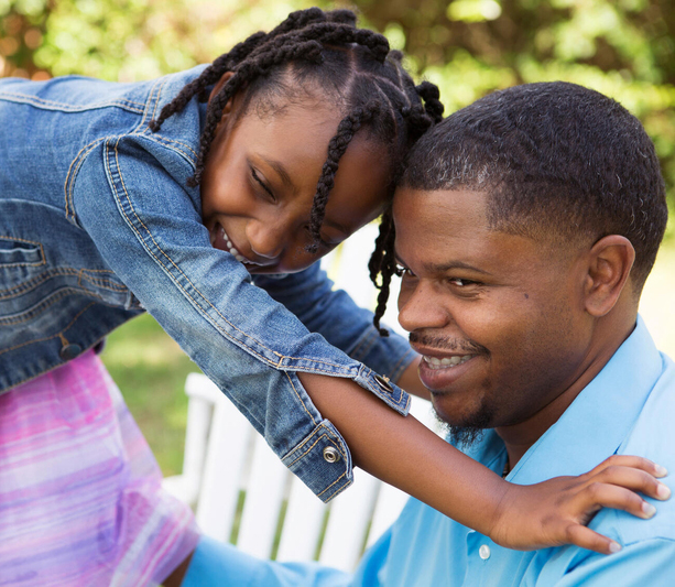 Father playing with daughter outside