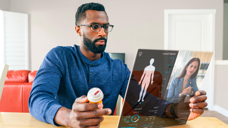Man holding prescription bottle and video calling with a doctor
