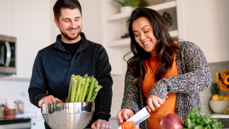 Couple cutting vegetables in their kitchen