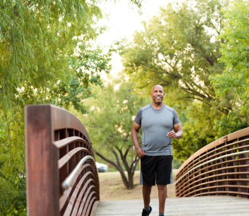 Man jogging on park bridge