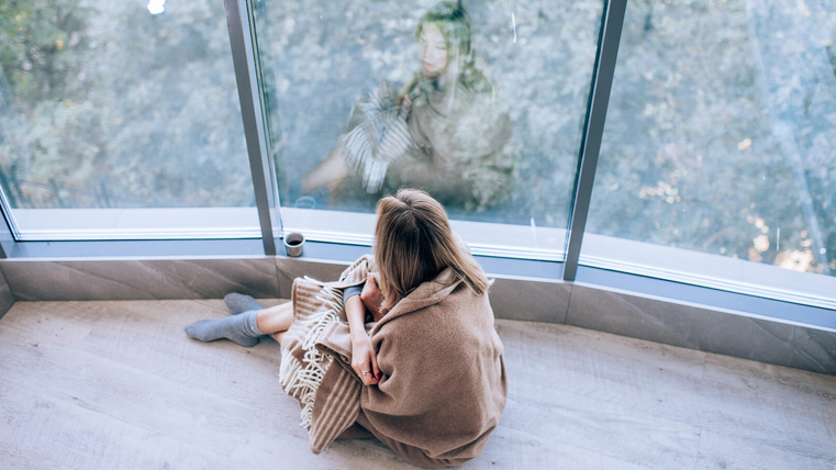 Woman sitting on floor looking out window