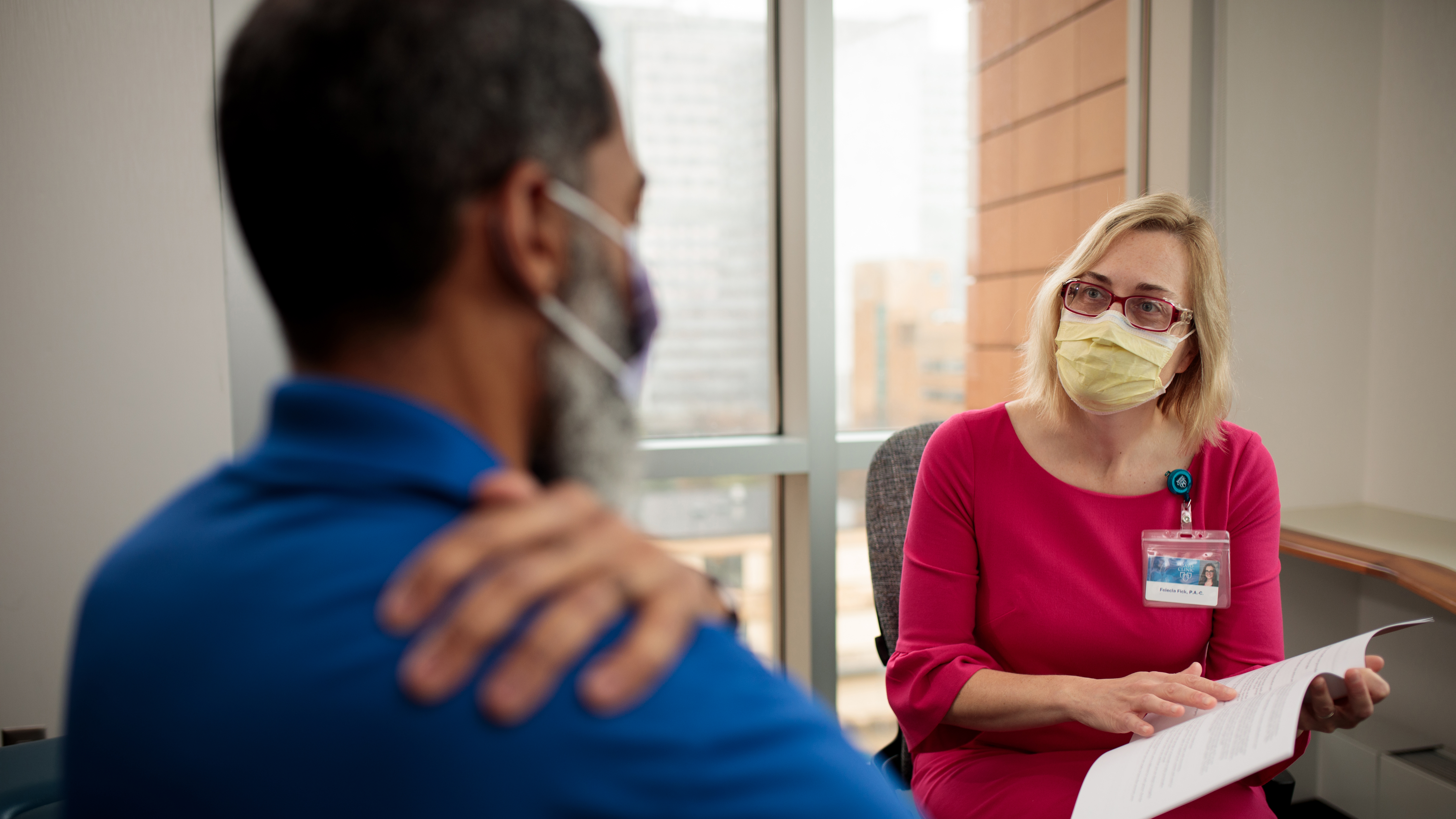 Masked doctor consulting with patient