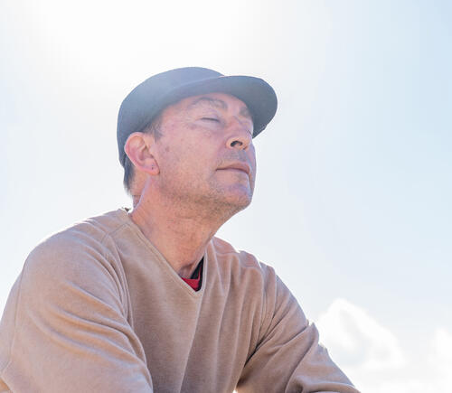 Man sitting in sun with eyes closed