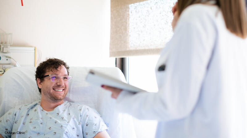 Patient in hospital bed smiling at doctor