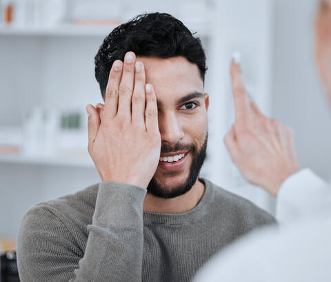 Man covering one eye during eye exam