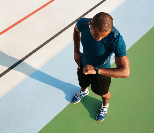 Man checking exercise watch on track