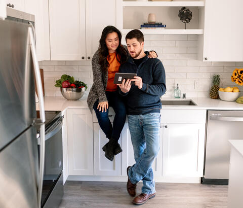 Couple looking at e-tablet in kitchen