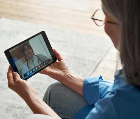 Woman using tablet for telehealth