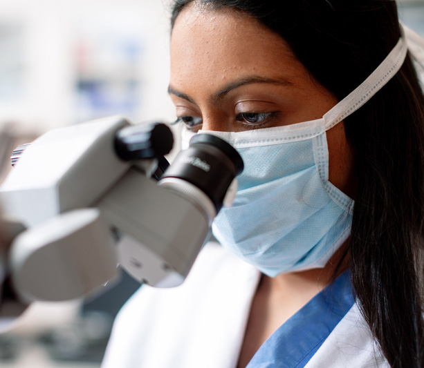 Researcher looking into microscope