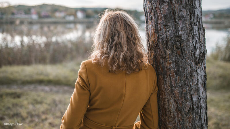 Woman in yellow jacket facing away from the camera