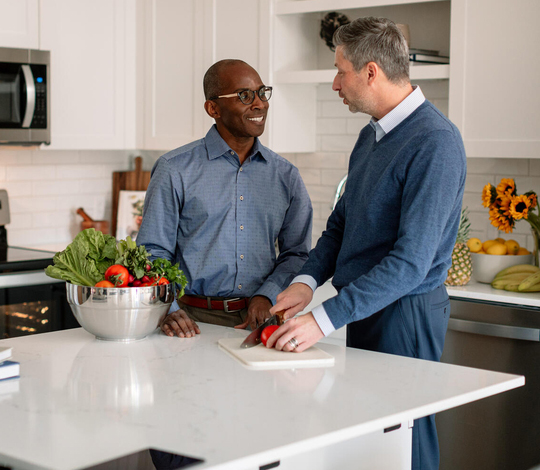 Couple cutting food in kitchen