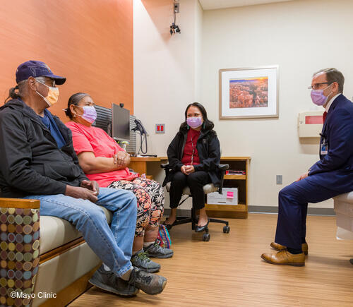 Man and woman meeting with care team in exam room.