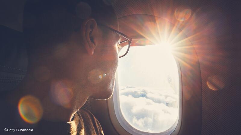 Adult looking out an airplane window