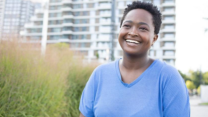 Woman smiling in front of a building