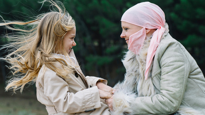 Mother with head scarf playing with daughter