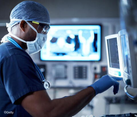 Masked doctor looking at monitors