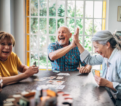 Older adults having fun playing cards together