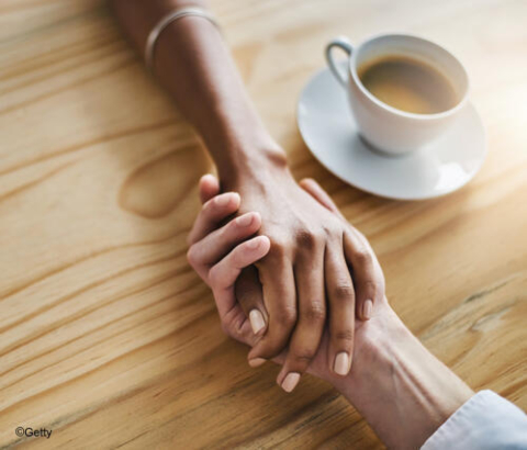 Two people holding hands across the table