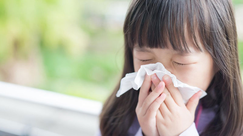 Girl blowing her nose