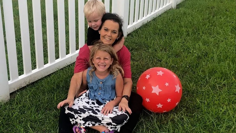 Adult white woman with two young children.