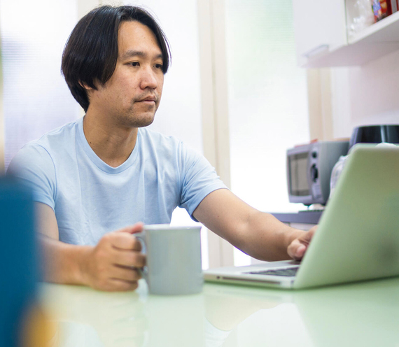 Man working on laptop and drinking coffee