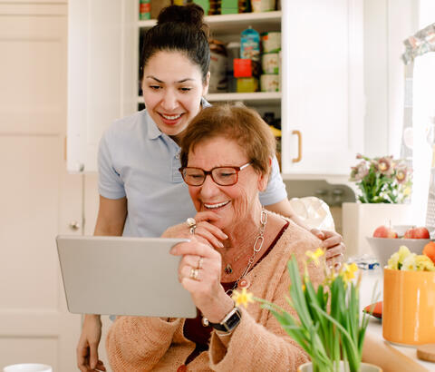 Grown daughter and mother looking at e-tablet