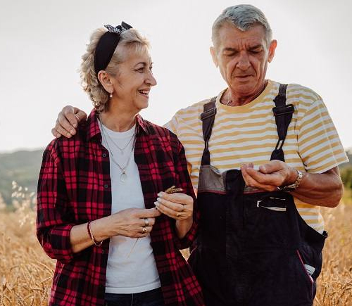 Older couple standing in wheat field