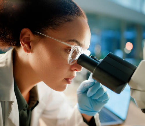Researcher looking into microscope
