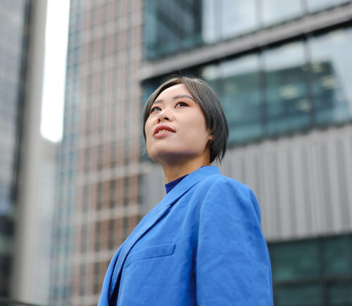 Person in blue blazer standing in city