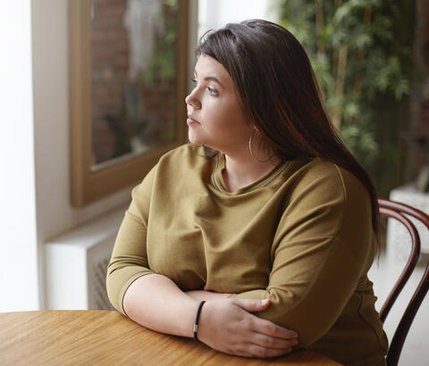 Woman at table looking off camera