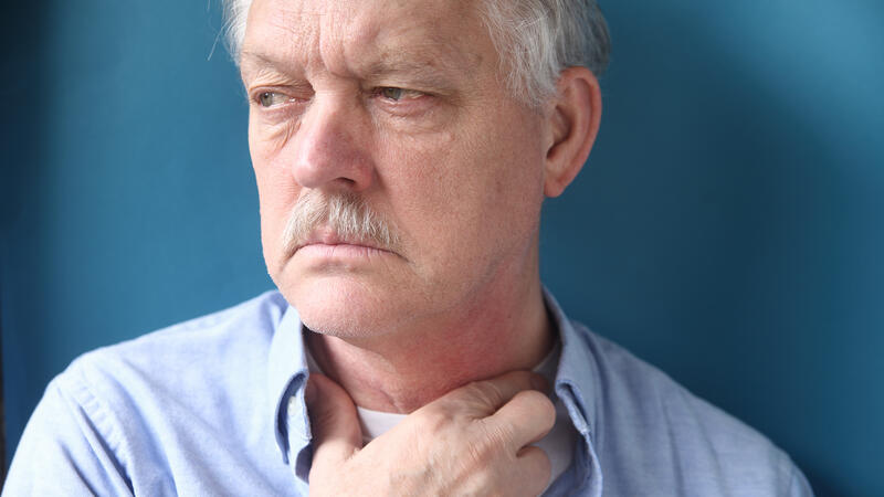 Man holding his throat