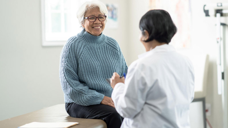 Woman visiting with medical professional in an exam room