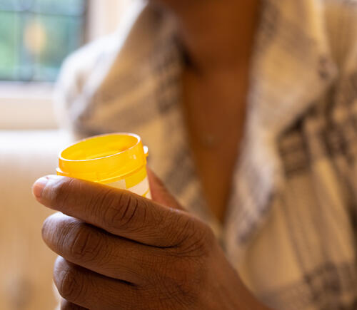Hand holding a prescription bottle