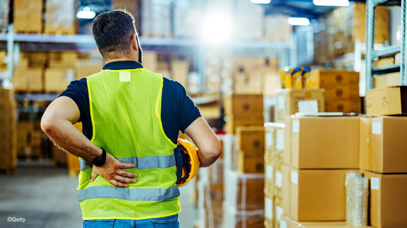 Warehouse employee holding his lower back