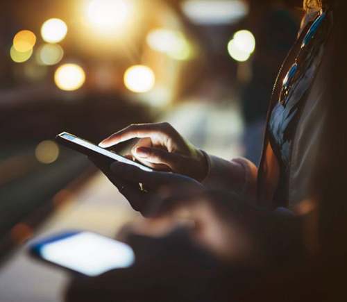 Woman using her phone at night in the city