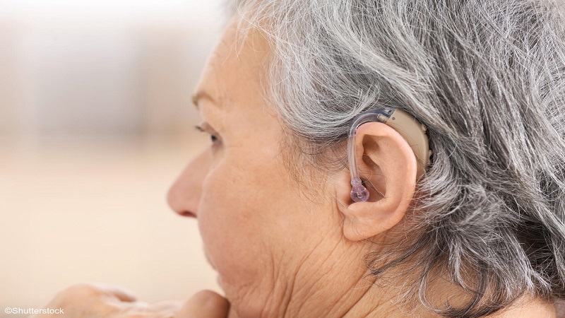 Older woman wearing a hearing aid.