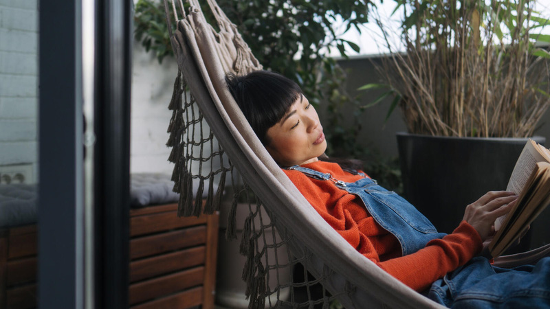 Woman in a hammock reading a book