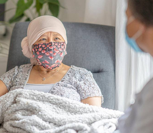 Masked person under blanket