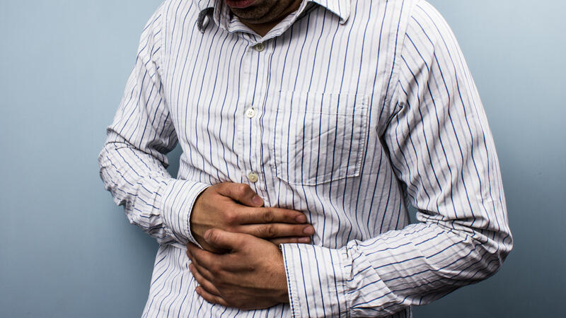 Man holding his stomach in discomfort