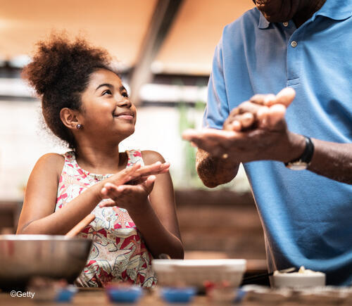 Man and young girl cooking togther.